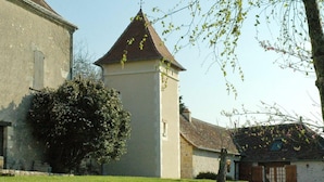 A church with a tower, a stone building, and a tree in front. - Charming 17th-century home in Touraine with private pool (Abilly)