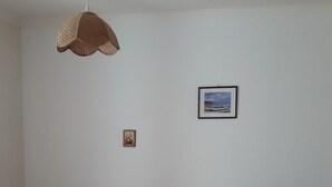 A bedroom with a wooden bed, two bedside tables with lamps, a hanging light fixture, and two framed pictures on the wall. - T3 with garden in mini farm 10 minutes from Thonon and Lake Leman (Allinges)