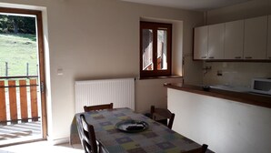 A small kitchen with white cabinets, a wooden countertop, and a window. - T3 with garden in mini farm 10 minutes from Thonon and Lake Leman (Allinges)