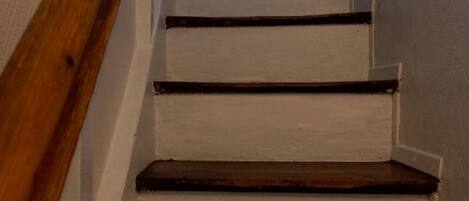 A staircase with wooden steps and white walls.