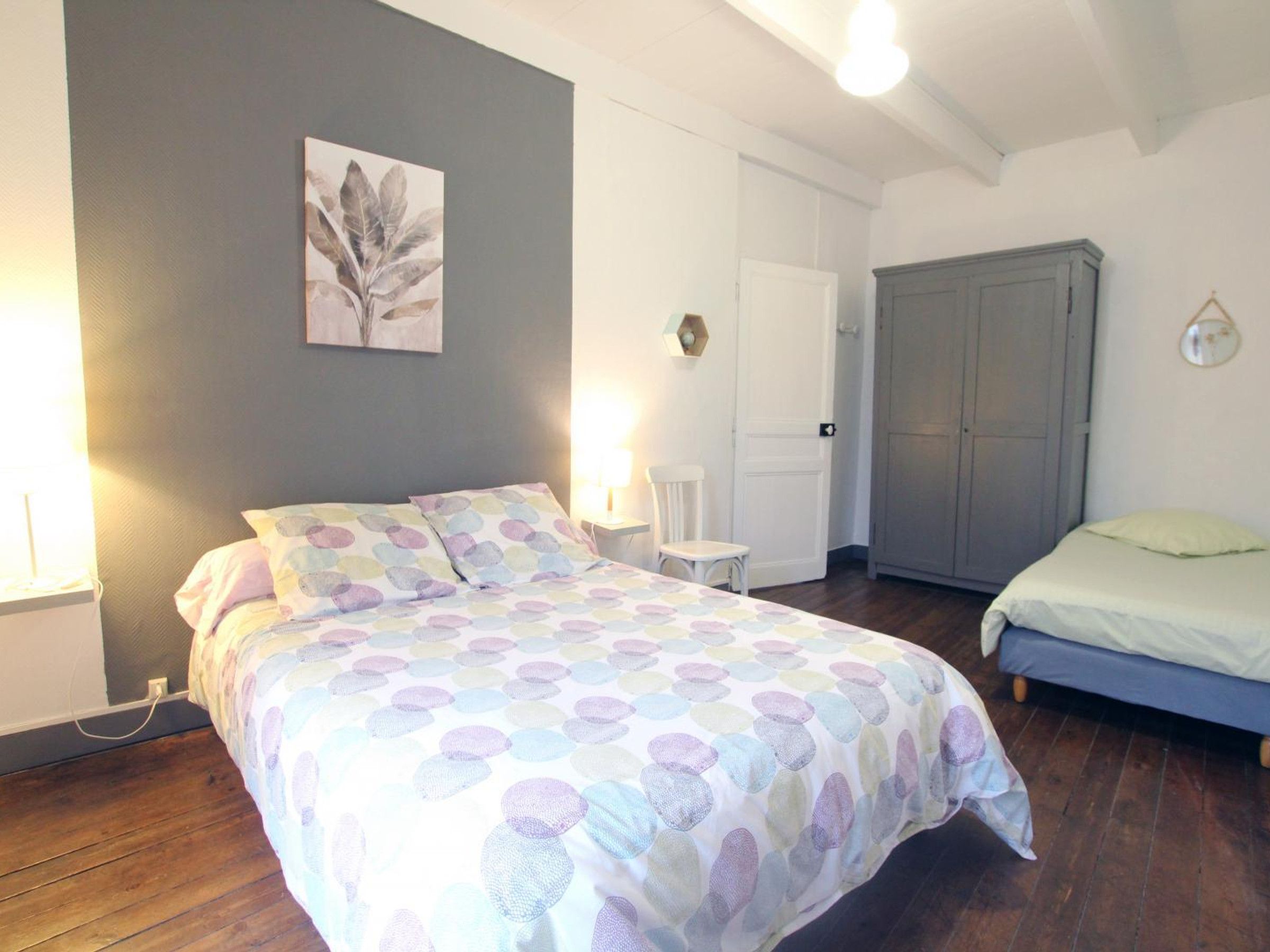 Een slaapkamer met een bed, een stoel, een kledingkast en een deur.