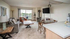 A modern living room with a sofa, coffee table, and dining area. - Gearhart House G607 (Gearhart)