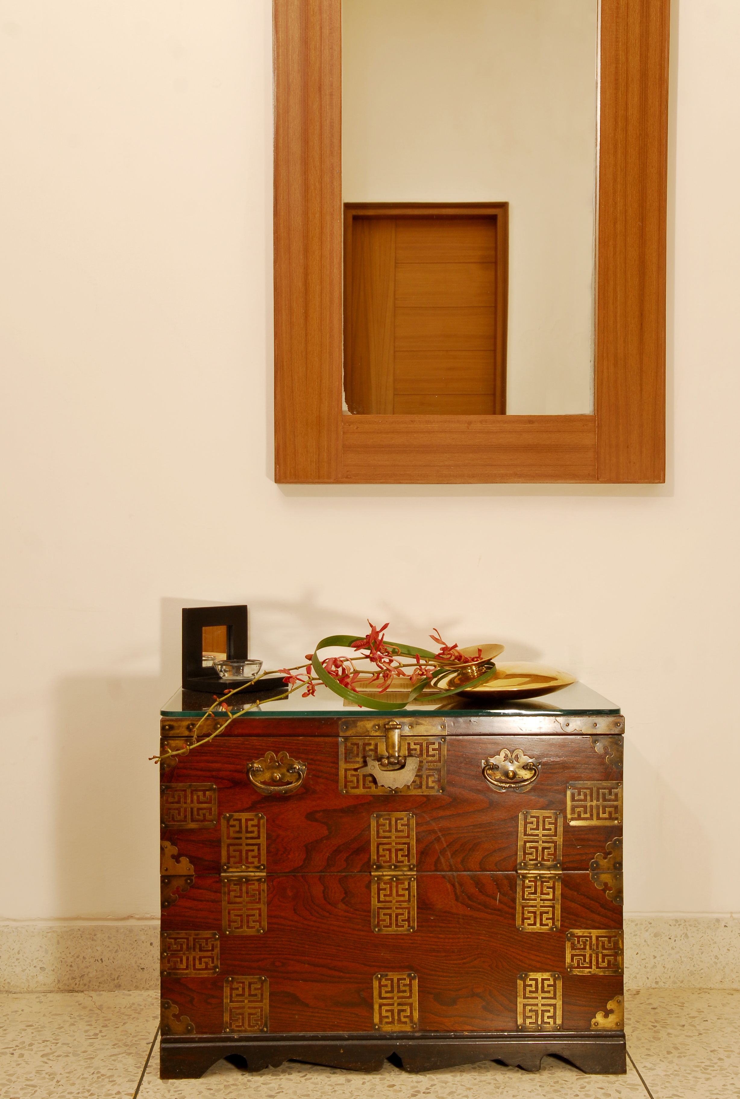 A wooden cabinet with intricate designs and a mirror above it.