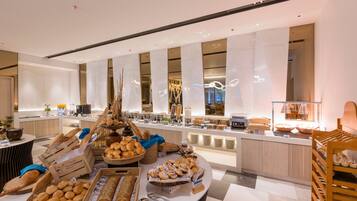 A buffet area with various breads and pastries.