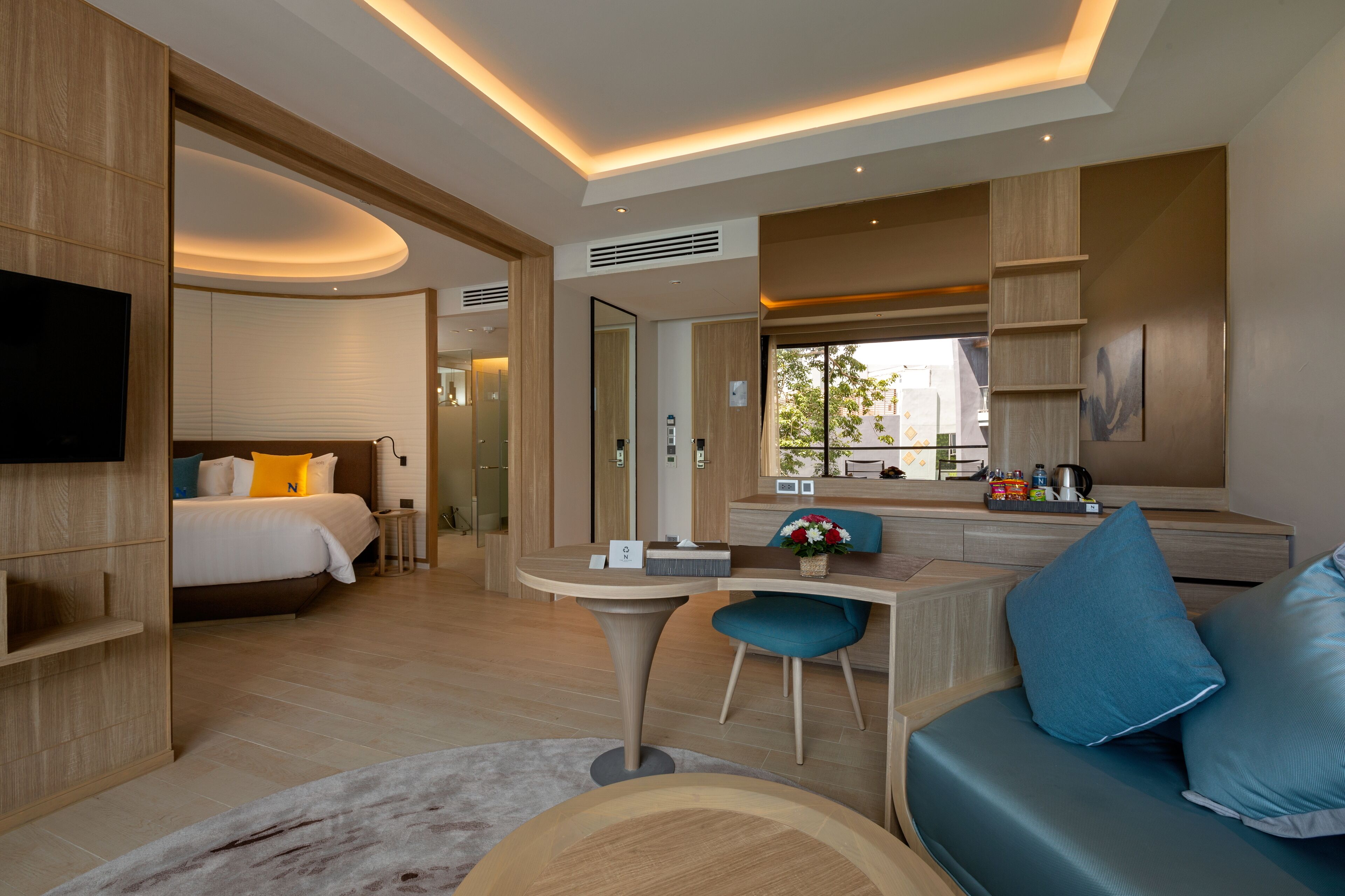 Une chambre d’hôtel moderne équipée d’un lit, d’un bureau, d’un canapé et d’une télévision.
