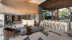 A spacious lobby with a bar area, seating, and a modern design. - The Nature Phuket (Patong)