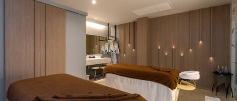 Una habitación de hotel moderna con dos camas, baño y zona de estar.