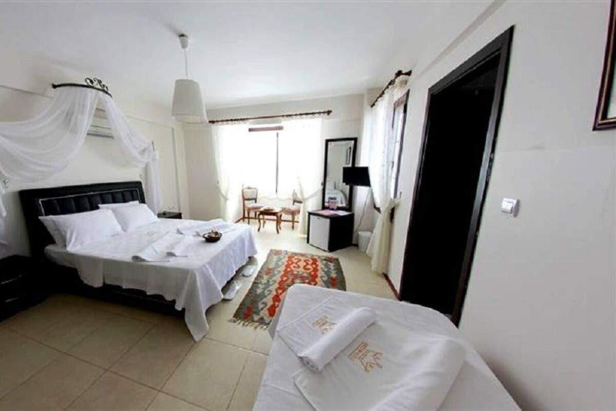 A hotel room with a bed, a desk, a chair, and a wardrobe.
