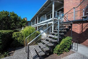 Ein Gebäude mit Ziegelaußenwand, einer Treppe mit Metallgeländern und einem überdachten Außenbereich.