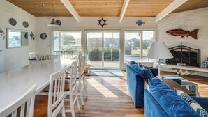A spacious kitchen with a large island, a dining area with chairs, a blue sofa, and a fish-themed fireplace.