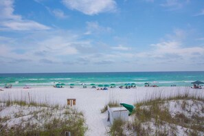A beach with a sandy foreground, a clear sky, and the ocean in the background. - Guest Favorite| Gulf Front | Accommodates 12 |  Beach Serv. I Pet Friendly| (Miramar Beach)