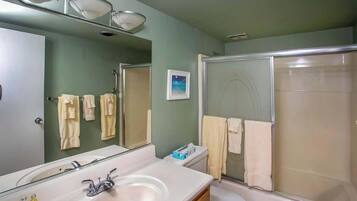 Ein Badezimmer mit Waschbecken, Spiegel und Dusche.