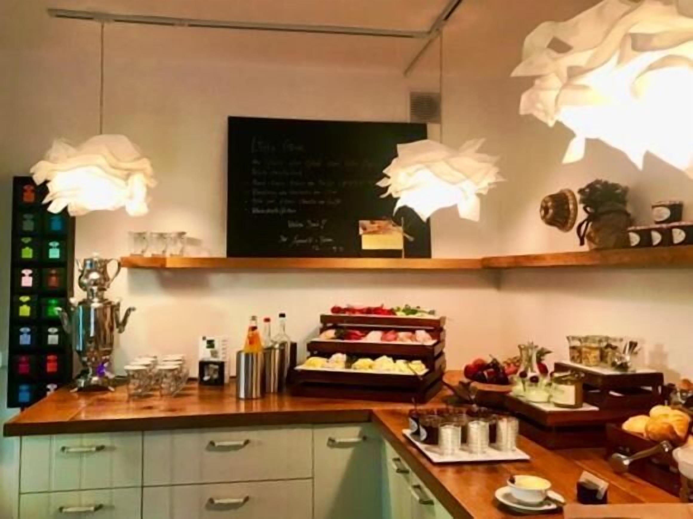 A cafe with a wooden counter, shelves with food items, and a chalkboard menu.