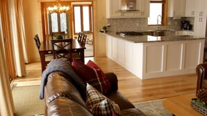 A modern kitchen with white cabinets, a granite countertop, and a stainless steel range hood.