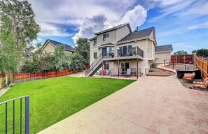 A two-story house with a covered patio, a fenced backyard, and a well-maintained lawn. - Mountain View! Near Park and Rec Center w/ Pool! (Colorado Springs)