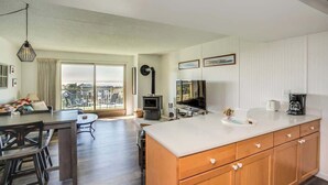 Una cocina moderna con una isla grande, un comedor y vistas a la ciudad.