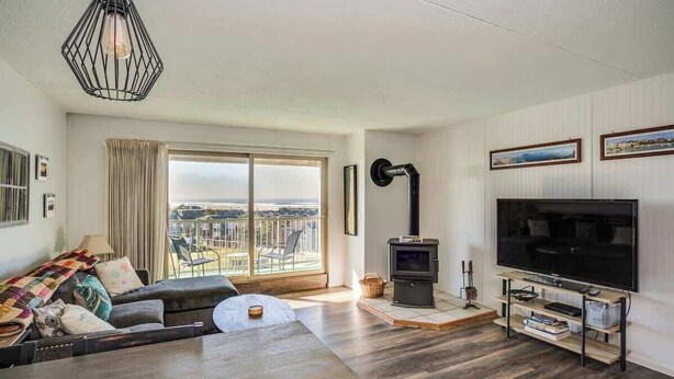Una sala de estar con sofá, televisión y chimenea.