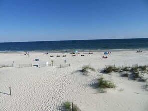 Une plage de sable avec des tentes et quelques personnes.