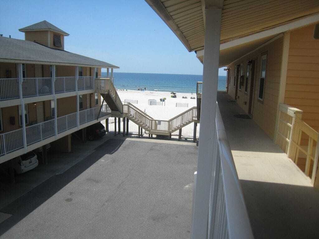 Un hôtel situé en bord de mer, doté d’une promenade couverte menant à la plage, de nombreux balcons et offrant une vue dégagée sur l’océan.