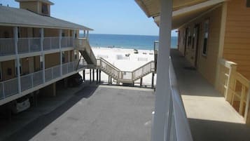 Un hôtel situé en bord de mer, doté d’une promenade couverte menant à la plage, de nombreux balcons et offrant une vue dégagée sur l’océan.