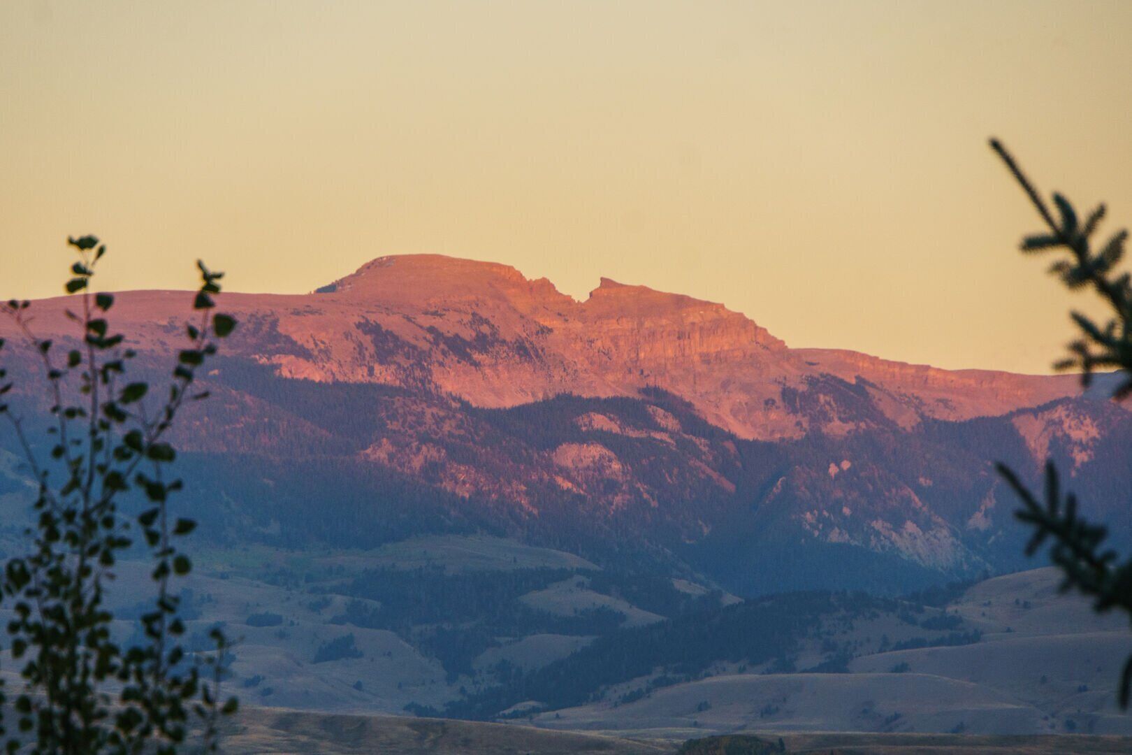 A mountainous landscape with a prominent peak and surrounding hills.