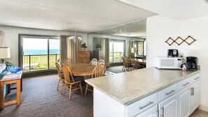 Ein Hotelzimmer mit Essbereich, Küche und einem Balkon mit Aussicht.