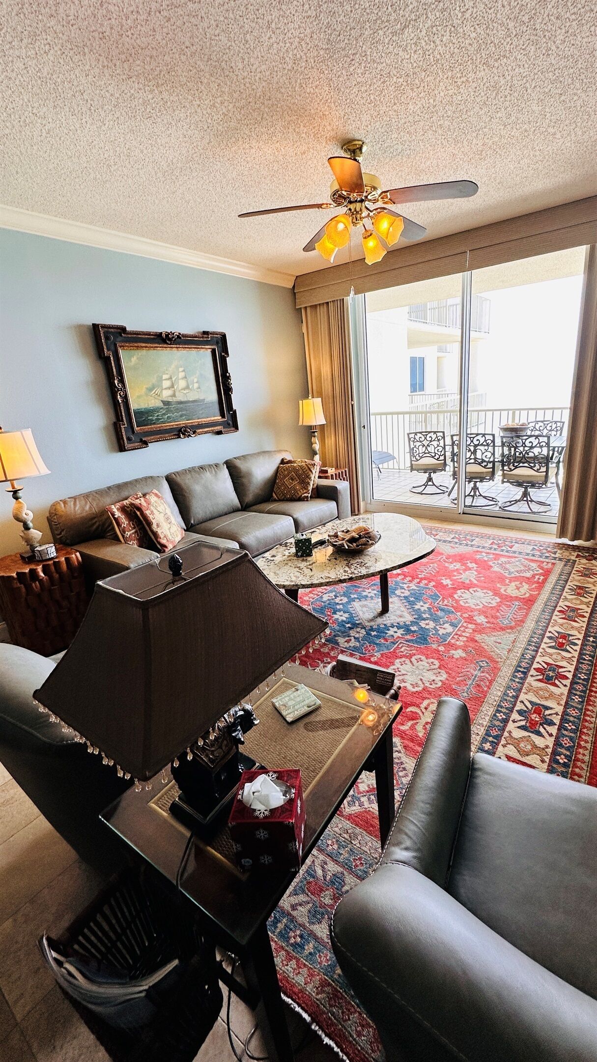 Un salon avec un canapé, une table basse et un tableau accroché au mur.