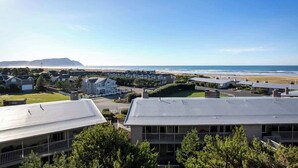 A coastal residential area with houses, a beach, and a mountain in the background.