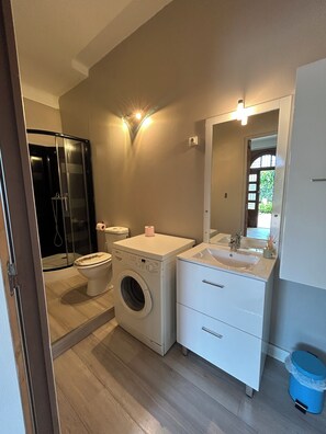 A bathroom with a washing machine, toilet, and sink. - Domaine Les feuilles de chêne (Carpentras)