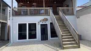 Ein zweistöckiges Gebäude mit einem Balkon, einer Holztreppe und einem Schild mit der Nummer 634.