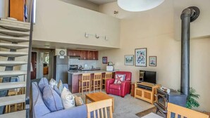 A compact living space with a kitchenette, a red leather sofa, a dining table, and a TV. - Gearhart House G700 (Gearhart)