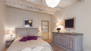 A bedroom with a bed, nightstands, a dresser, and a door. - La Louvière des Bruyères (Robion)