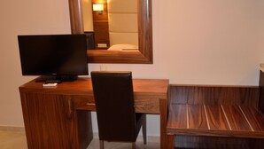 A wooden desk with a television, a chair, and a mirror. - 4-You Residence (Sithonia)