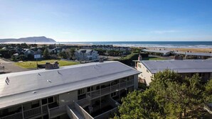A coastal residential area with houses, a beach, and a clear sky. - Gearhart House G670 (Gearhart)