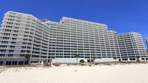 Un hotel de varios pisos con balcones, situado en la playa.