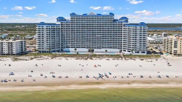 Un hotel grande con varios pisos y vista al mar.