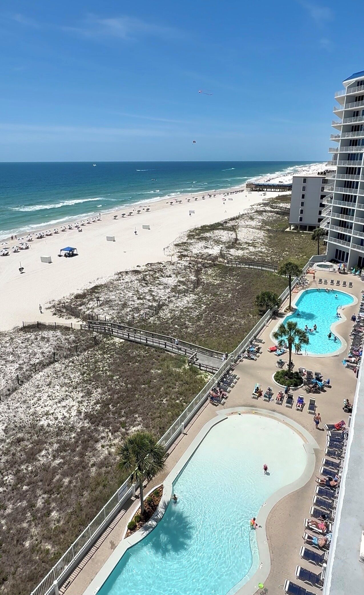 A resort with a beach, a pool, and a view of the ocean.