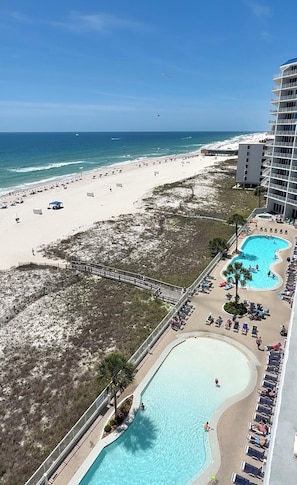 A resort with a beach, a pool, and a view of the ocean.