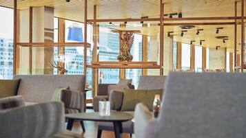 Een modern interieur met houten balken, glazen scheidingswanden en zithoeken.