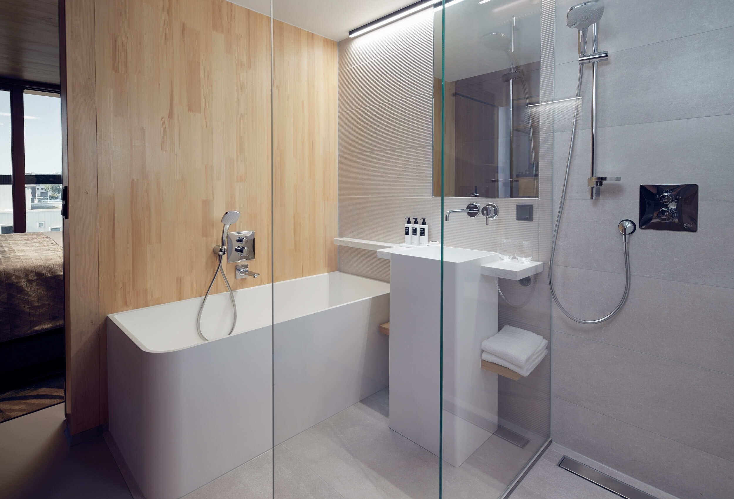 A modern bathroom with a freestanding bathtub, a glass-enclosed shower, and a white sink.