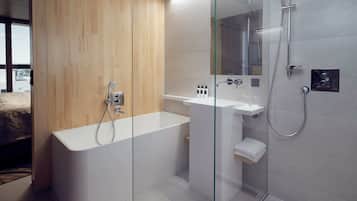 A modern bathroom with a freestanding bathtub, a glass-enclosed shower, and a white sink.