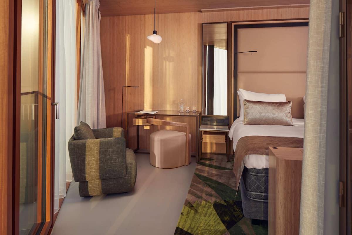 Une chambre d’hôtel moderne équipée d’un lit, d’un bureau, d’une chaise et d’un canapé.