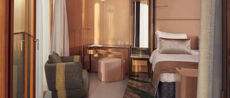 Una habitación de hotel moderna con una cama, un escritorio, una silla y un sofá.