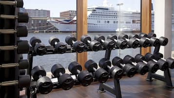 A gym with a weight rack filled with dumbbells.