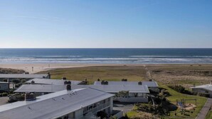 Une zone résidentielle côtière avec des maisons, une plage et un ciel dégagé.