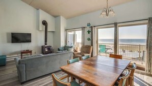 Un salon avec une table à manger en bois, un canapé et un téléviseur.