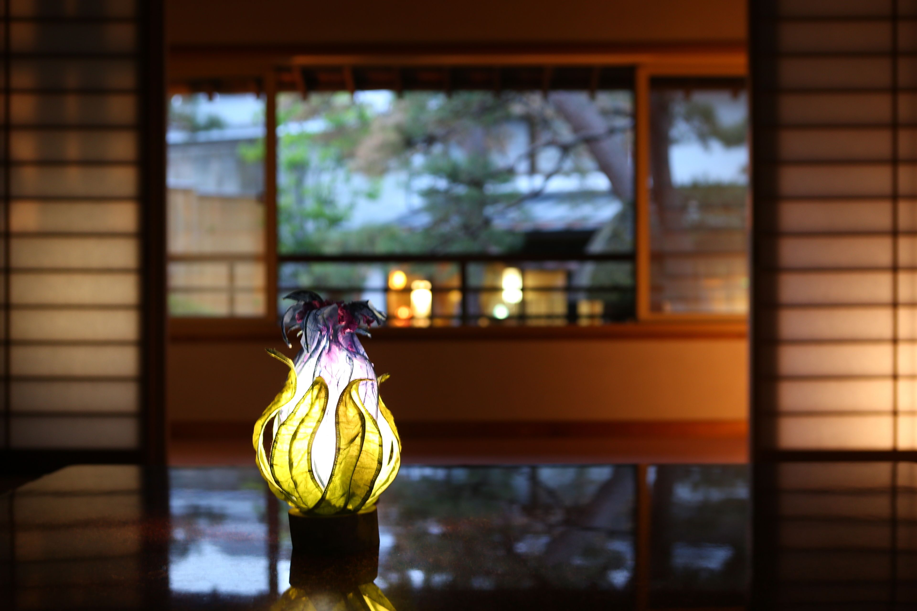 A lamp with a floral design on a reflective surface.