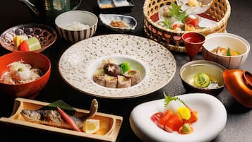 Eine Auswahl japanischer Gerichte auf einem Tisch, darunter Sushi, Sashimi und weitere Köstlichkeiten.