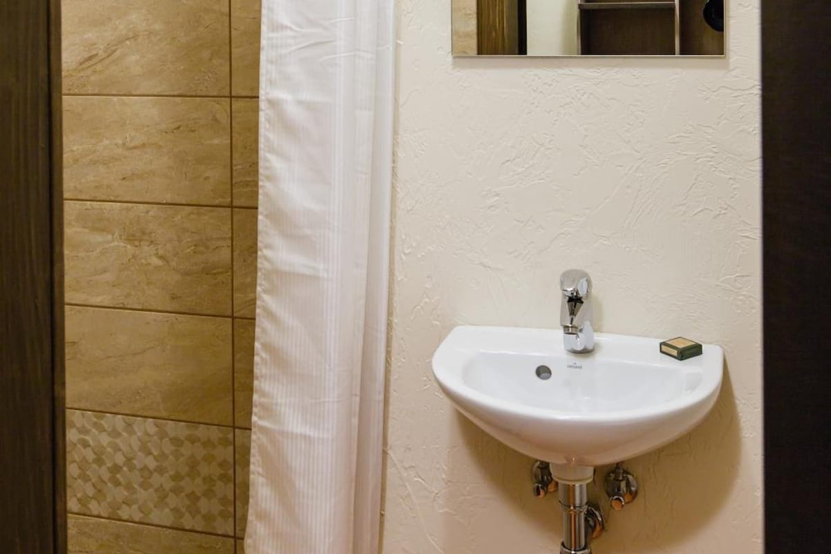 A bathroom with a shower, a sink, and a mirror.