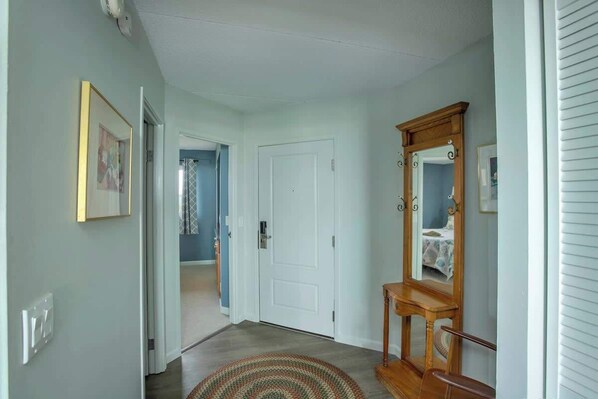 A hallway with a door, a mirror, and a rug. - Gearhart House G697 (Gearhart)